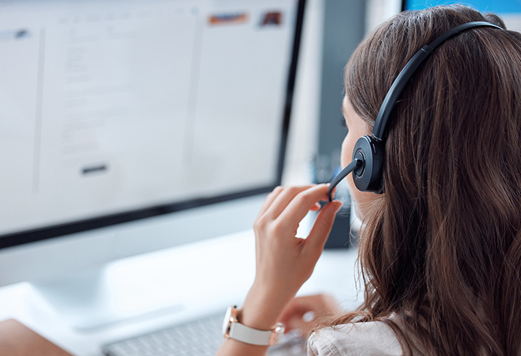 BPO sind eine wertvolle Option für Unternehmen, die ihren Kundenservice optimieren möchten Frau mit Headset vor einem Bildschirm