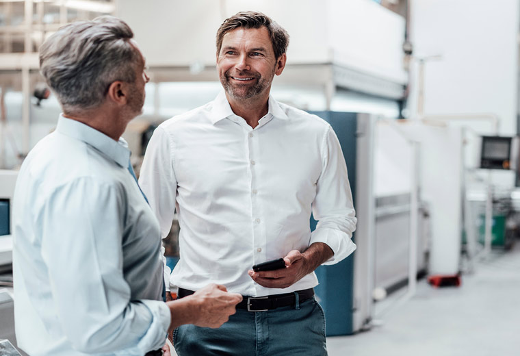 Industrie Telefonielösung 2 Männer im Gespräch in einer Industriehalle